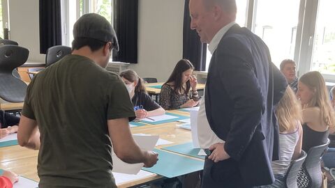 EU-Projekttag 2022 an der Albert-Schweitzer-Schule Kassel Europastaatssekretär Uwe Becker zusammen mit den Schülern bei der Aufgabenbeschreibung