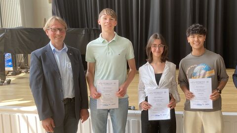 EU-Projekttag 2022 an der Albert-Schweitzer-Schule Kassel Europastaatssekretär Uwe Becker zusammen mit Schülern vor der Bühne in der Aula