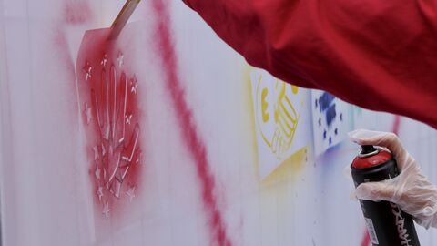 Impressionen - Europawoche 2022- Berufliche Schule Gelnhausen Europaministerin Lucia sprüht ein rotes Herz auf eine Wand der Beruflichen Schule Gelnhausen