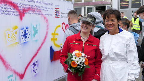 Impressionen - Europawoche 2022- Berufliche Schule Gelnhausen Europaministerin Lucia sprüht ein rotes Herz auf eine Wand der Beruflichen Schule Gelnhausen