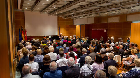 Das Bild stellt eine Aufnahme der sitzenden Gäste im Büchnersaal der hessischen Staatskanzlei dar. 
