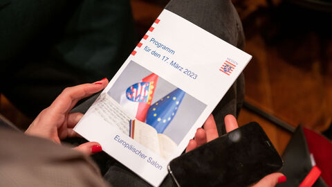 17. Europäischer Salon mit der Ukraine am 17. März 2023 Ein Gast hält das Programm des Abends in den Händen