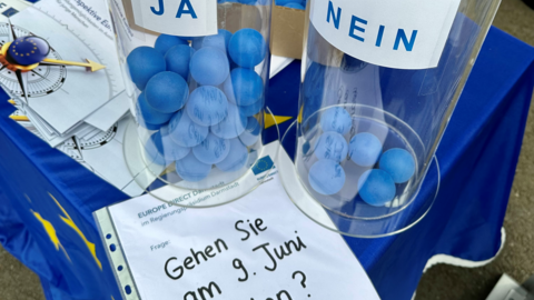 Gehen Sie am 9. Juni wählen? Es sind zwei Glaszylinder zu sehen, einer mit JA und einer mit NEIN beschriftet. Auf einem davor liegenden Zettel steht: Gehen Sie am 9. Juni wählen? In den Zylindern liegen blaue Bälle, in dem Ja-Zylinder liegen jedoch deutlich mehr Bälle.