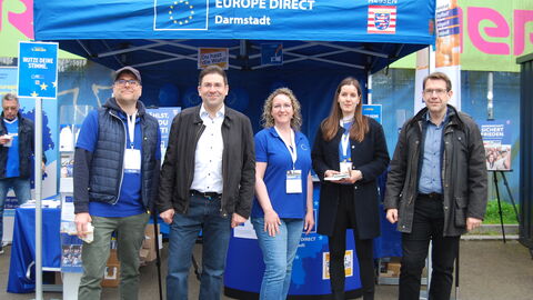 Das Team vom Informationsstand mit Darmstadts Oberbürgermeister, Hanno Benz. Auf dem Foto sind Mitarbeiterinnen und Mitarbeiter des Europe Direct Darmstadt und der Hessischen Staatskanzlei mit dem Oberbürgermeister von Darmstadt, Hanno Benz, zu sehen.