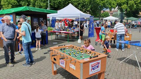 Tischkicker am Europafest Es ist ein Tischkicker vor den Ständen des Europafestes zu sehen, im Hintergrund laufen Menschen entlang.