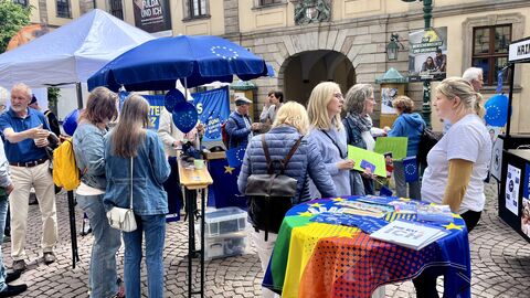 Bürgerinnen und Bürger informieren sich am Stand zur Europawahl Es sind Bürgerinnen und Bürger zu sehen, die sich zur Europawahl informieren und ins Gespräch vertieft sind.