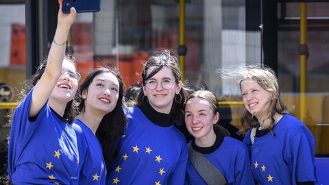Schülerinnen machen ein Selfie vor dem Bus