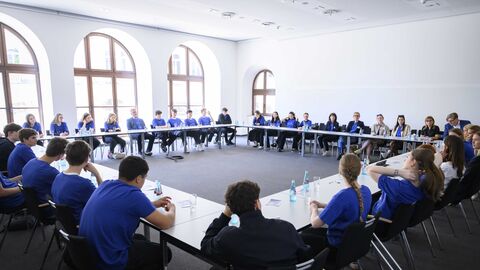 Europadezernentin der Stadt Wiesbaden im Gespräch mit der Schulkasse in einem Sitzungssaal im Rathaus