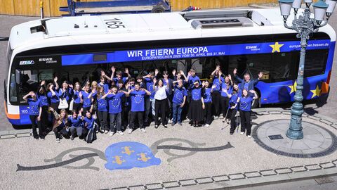 Schulkasse und Europadezernentin winkend vor dem Bus, aufgenommen von oben